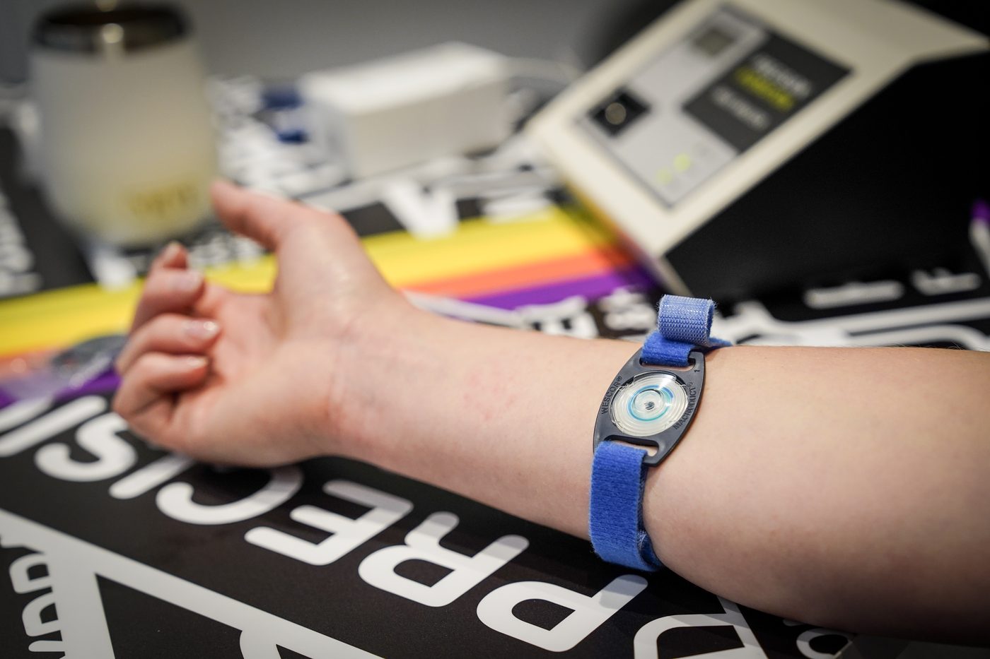 Collecteur de sueur sangl&eacute; sur l'avant-bras d'un athl&egrave;te pendant un sweat test, devant l'analyseur.